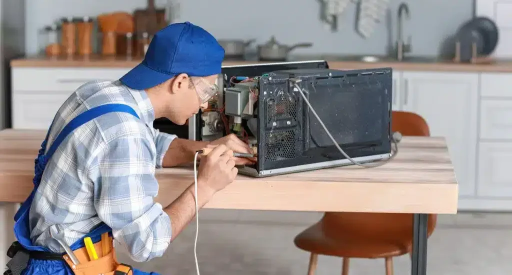 Worker-Repairing-Microwave-oven-in-kitchen